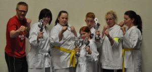 De deelnemers en coaches van Joong-Gun poseren in gevechthouding met de gewonnen trofeëen De deelnemers en coaches van Joong-Gun poseren in gevechthouding met de gewonnen trofeëen