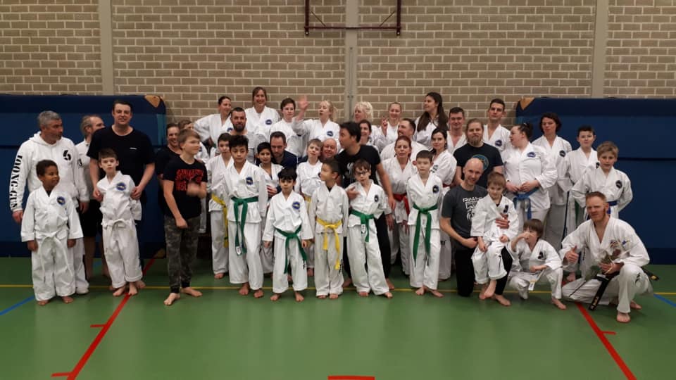 de kinderen poseren met hun vader of moeder en de trainers en volwassen studenten de kinderen poseren met hun vader of moeder en de trainers en volwassen studenten