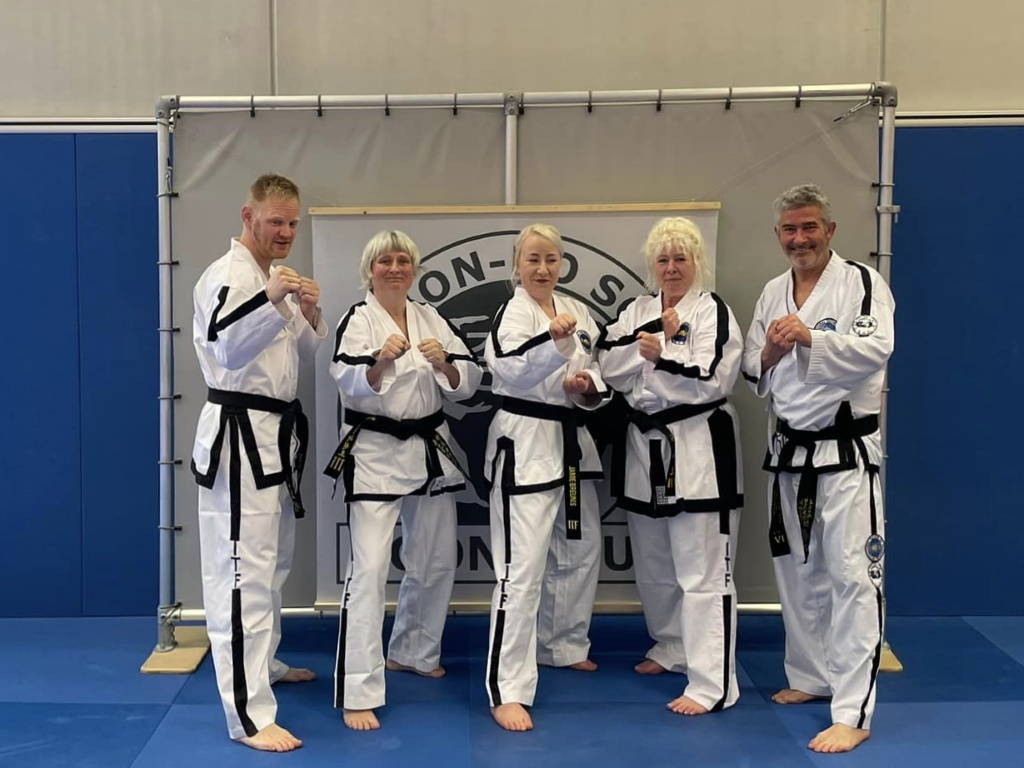 Mark, Barbara, Jamie en Gretha poseren met instructeur Brandt in de sportzaal Mark, Barbara, Jamie en Gretha poseren met instructeur Brandt in de sportzaal